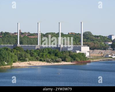 Die Stadtwerke Kiel Kieler Blockheizkraftwerk am Wasserrand mit 4 hohen, schlanken Schornsteinen sichtbar. Stockfoto