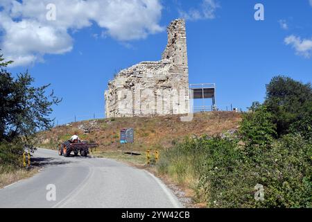 Amfipoli, Griechenland - 15. Juni 2024: Teil der befestigten Mauer mit Informationstafel und Landwirt auf der Traktorstraße in der antiken Stätte Amphipolis in Central Ma Stockfoto