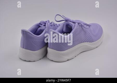 Neue Freizeitschuhe für Damen im Frühling. Weiche lila Sport-Mokassins, weiche Sneakers aus synthetischem Mesh, Stoff mit weißer Sohle. Stockfoto