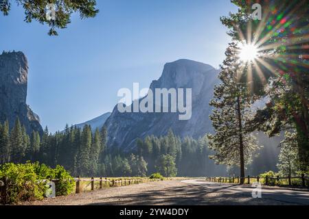 Ein atemberaubender Blick auf den Half Dome im Yosemite Valley National Park, während die Sonne den riesigen Monolithen besticht. Ein mehrspitzer Sonnenstern wird erzeugt. Stockfoto