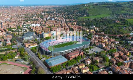 Ein atemberaubender Blick aus der Vogelperspektive auf Bolognas berühmtes Renato Dall'Ara Stadion, umgeben von einer lebhaften Stadtlandschaft und üppigen grünen Hügeln. Charme der historischen italienischen Stadt Stockfoto