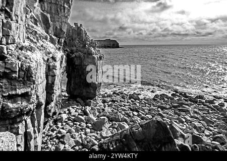 Dramatischer Schwarzweiß-Blick auf den schmalen Meeresbogen am St Govan’s Head entlang der Küste von Pembrokshire in Wales Stockfoto