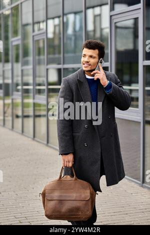 Ein gut gekleideter Mann führt ein Telefongespräch, während er an einem modernen Bürobereich vorbeischlendert. Stockfoto