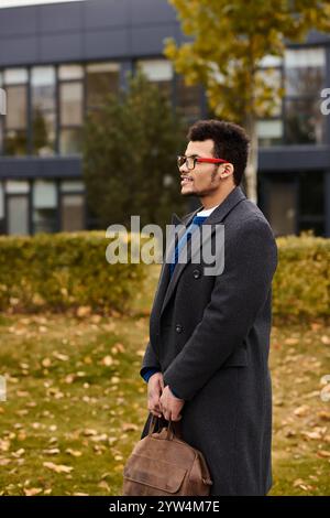 Ein charmanter Mann steht ruhig in einem Park und genießt die Schönheit der Herbstsaison. Stockfoto
