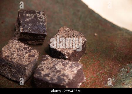 Bio-Schokolade aus der Region Oaxaca in Mexiko, die auf traditionelle Weise auf einem Metat hergestellt wird, einem alten Steinwerkzeug zum Mahlen von Produkten. Stockfoto