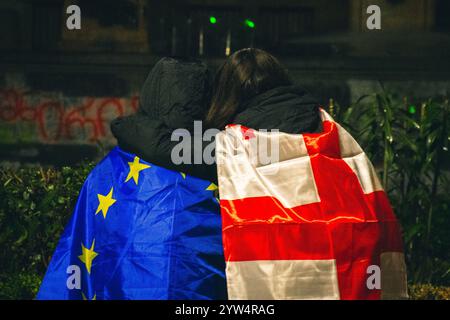 Tiflis, Georgien - 1. dezember 2024: Zwei Mädchen umarmen sich vereint für Georgien und die EU-Integration. Demonstranten georgier durch das parlament protestieren und stehen Stockfoto