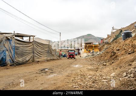 Lurin, Peru — 29. Juli 2023: Ländliche Straße mit Tuktuk in einem trockenen, sich entwickelnden Viertel in den Bergen bei Lima Stockfoto