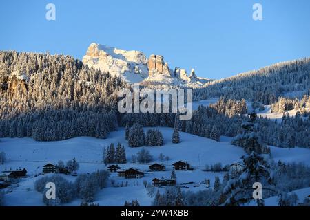 Cortina d’Ampezzo innevata: vista sulle Cinque Torri e Monte Averau e alcune Case del paese. Foto scattata al primo mattino. Stockfoto