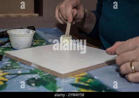 Farbe mit einem Pinsel auf Leinwand auftragen Stockfoto