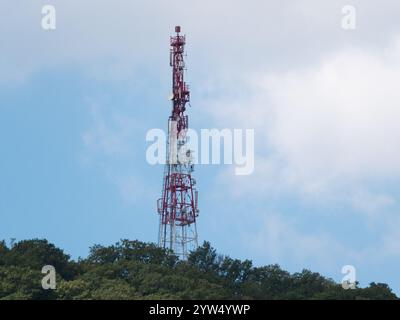 Direktionales Antennenarray auf einem rot-weißen Kommunikationsturm gegen den Himmel. Stockfoto