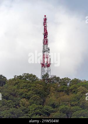 Direktionales Antennenarray auf einem rot-weißen Kommunikationsturm gegen den Himmel. Stockfoto