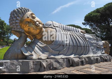 Großer Granit-Buddha oder liegender Buda, im Hintergrund des blauen Himmels, im Park Bacalhôa Buddha Eden oder im Garten des Friedens. Portugal. Stockfoto