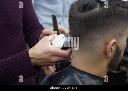 Friseur und Friseur für Herren mit Haarschneider in einem Friseur oder Friseursalon, Nahaufnahme Stockfoto