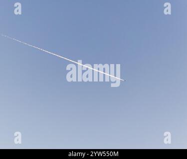 Kondensstreifen aus einem hochfliegenden Flugzeug am blauen Himmel über Worthing, West Sussex, Großbritannien Stockfoto