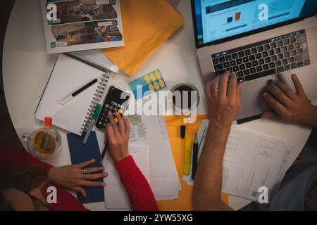 Zwei Leute arbeiten zusammen an einem Laptop, ein Paar organisiert Kreditdokumente. Neues Hauskonzept. Stockfoto