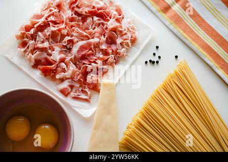 Zutaten für Carbonara Pancetta, Eier und Spaghetti auf weißem Hintergrund, Draufsicht Stockfoto