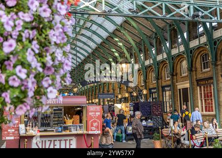 London, Großbritannien – 19. September 2024: Der lebhafte Covent Garden Apple Market in London mit Cafés, Verkaufsständen und Shoppern unter dem historischen Green Iron Roof. Stockfoto