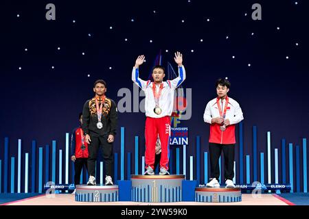 Bin Kasdan Mohamad Aniq aus Malaysia, Silber, Myong Jin Pak aus Nordkorea, Gold, Haixian Wei aus China, Bronzestelle mit der Medaille nach Teilnahme an der Clean & Jerk, in der Kategorie 61 kg Männer während der IWF Weltmeisterschaft 2024 in der IWF Arena in Manama, Bahrain, 07. Dezember 2024. Stockfoto