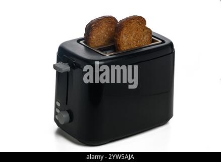 Frisch geröstete Brotscheiben aus einem stilvollen schwarzen Toaster strahlen Wärme in einer gemütlichen Küchenumgebung aus. Stockfoto