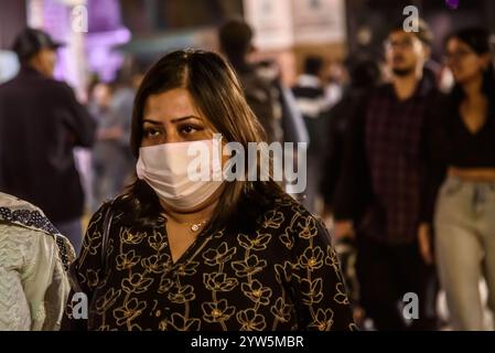 Eine Frau mit chirurgischer Gesichtsmaske protestiert am 8. Dezember 2024 an einem Veranstaltungsort des 30. Internationalen Filmfestivals in Kalkutta, Indien, gegen Luftverschmutzung. Bilder von Debajyoti Chakraborty. (Foto: Debajyoti Chakraborty/News Images) in, am 12.9.2024. (Foto: Debajyoti Chakraborty/News Images/SIPA USA) Credit: SIPA USA/Alamy Live News Stockfoto