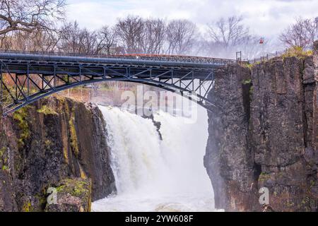 Great Falls Wasserfall und Stahlbogenbrücke umgeben von nebeliger Frühlingslandschaft in Paterson, New Jersey. Stockfoto
