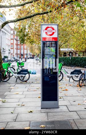 London, Großbritannien - 17. November 2024: Karte von Mayfair auf Fahrradstand, Wegbeschreibung zum Green Park und hyde Park, Lime Elektrofahrräder im Hintergrund Stockfoto