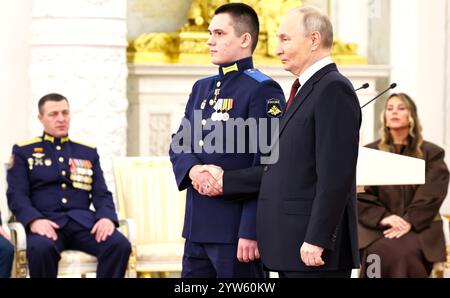 Moskau, Russland. Dezember 2024. Der russische Präsident Wladimir Putin vergibt die Goldstermedaille an den Helden von Russland, an den Privaten Alexej Asylchanow, während einer Zeremonie zum Tag der Helden des Vaterlandes im Saal des Großen Kreml-Palastes am 9. Dezember 2024 in Moskau, Russland. Quelle: Alexander Kazakov/Kreml Pool/Alamy Live News Stockfoto