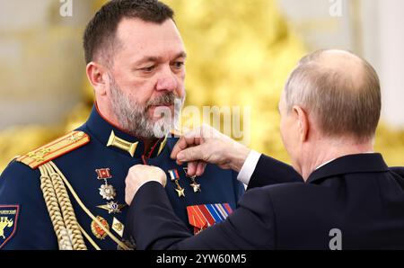 Moskau, Russland. Dezember 2024. Der russische Präsident Wladimir Putin vergibt die Goldstermedaille an den Helden von Russland, Dmitry Sablin, während einer Zeremonie zum Tag der Helden des Vaterlandes in der Halle des Großen Kreml am 9. Dezember 2024 in Moskau, Russland. SABLIN, ein in der Ukraine geborener russischer Nationalist, ist auch der erste stellvertretende Vorsitzende der Combat Brotherhood Veterans Organization. Quelle: Alexander Kazakov/Kreml Pool/Alamy Live News Stockfoto