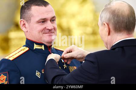 Moskau, Russland. Dezember 2024. Der russische Präsident Wladimir Putin überreichte die Goldstermedaille an den Helden von Russland, den Kommandeur einer Angriffseinheit, Captain Valery Enin, während einer Zeremonie zum Tag der Helden des Vaterlandes in der Halle des Großen Kreml-Palastes am 9. Dezember 2024 in Moskau, Russland. Quelle: Alexander Kazakov/Kreml Pool/Alamy Live News Stockfoto