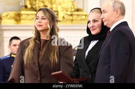 Moskau, Russland. Dezember 2024. Der russische Präsident Wladimir Putin verlieh die Goldstermedaille an den Helden von Russland, posthum an die Mutter des Oberleutnants Michail Izbakiev Marina und seiner Witwe Anna Mitkowa, die während einer Zeremonie zum Tag der Helden des Vaterlandes in der Halle des Großen Kreml-Palastes am 9. Dezember 2024 in Moskau, Russland, verließen. Quelle: Alexander Kazakov/Kreml Pool/Alamy Live News Stockfoto