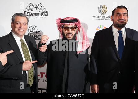 Hamburg, Deutschland. Dezember 2024. Boxen: Abend der Legenden, Galaabend der Legenden, im Hotel Grand Elysee. Turki Al-Sheikh (M), Saudi-arabischer Geschäftsmann, Sportfunktionär und Berater des königlichen Hofes, steht zwischen Mauricio Sulaiman (l), Präsident der WBC, und Prinz Abdullah bin Khaled bin Sultan bin Abdulaziz Al Saud, saudiarabischer Botschafter in Deutschland, vor dem Ballsaal. Quelle: Marcus Brandt/dpa/Alamy Live News Stockfoto