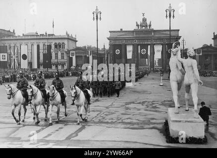 Eröffnung der Olympischen Spiele in Berlin. Marsch der Truppen des Dritten Reiches durch das Brandenburger Tor. Sichtbare Menschenmassen beobachten das Spektakel. Darüber befinden sich die Flaggen der Länder, die an den Olympischen Spielen teilnehmen. Archivfoto der Olympischen Sommerspiele 1936 in Berlin Stockfoto