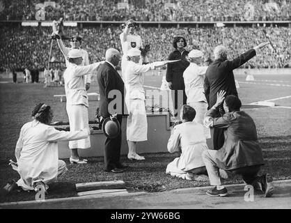 Medaillenzeremonie für Speerwettbewerb für Frauen. Auf dem Podium von rechts: Polens Maria Kwaśniewska (Bronze), Deutschlands Tilly Fleischer (Gold) und Deutschlands Luise Kruger (Silber). Sowohl deutsche Athleten als auch Beamte mit Gruß, Archivfoto der Olympischen Sommerspiele 1936 in Berlin Stockfoto