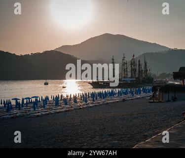 Die Sonne untergeht hinter den Bergen abendliche Meereslandschaft mit einem großen Schiff im Vordergrund. Hochwertige Fotos Stockfoto