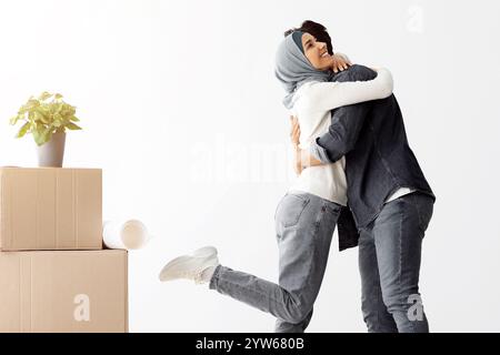 Emotionale muslimische Dame umarmt ihren Mann, zieht ein Stockfoto