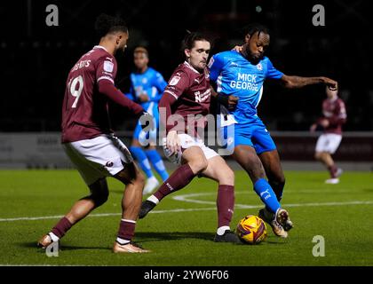 Ben Fox von Northampton Town (Mitte) und Ricky-Jade Jones von Peterborough United (rechts) kämpfen um den Ball während des Spiels der Sky Bet League One im Sixfields Stadium in Northampton. Bilddatum: Montag, 9. Dezember 2024. Stockfoto