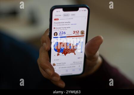 Ein Wähler googelt das Endergebnis der US-Präsidentschaftswahlen auf einem iPhone. Donald Trump gewann die Wahl, gewann 30 staaten mit 312 Wahlen... Stockfoto