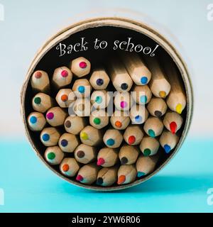 Bunte Buntstifte vor weißem und blauem Hintergrund. Minimales Schulkonzept. Trendige BACK-TO-SCHOOL-Idee. Stockfoto