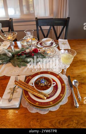 Enteneintopf und Brotstangen auf feinem Porzellan stellen Platz auf einem Weihnachtstisch. Stockfoto