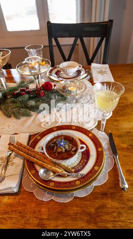 Enteneintopf und Brotstangen auf feinem Porzellan stellen Platz auf einem Weihnachtstisch. Stockfoto