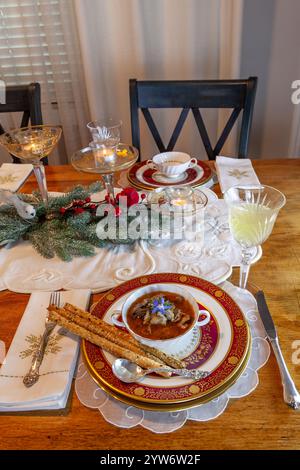 Enteneintopf und Brotstangen auf feinem Porzellan stellen Platz auf einem Weihnachtstisch. Stockfoto