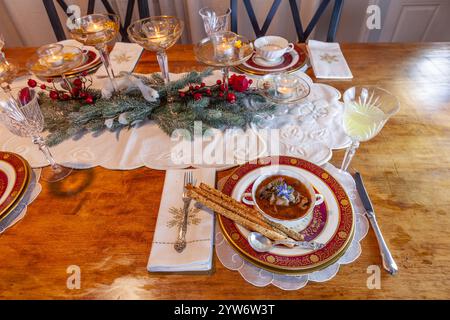 Enteneintopf und Brotstangen auf feinem Porzellan stellen Platz auf einem Weihnachtstisch. Stockfoto