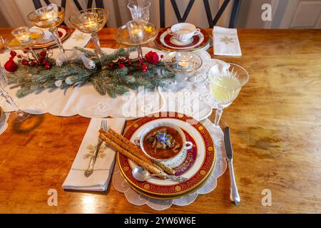 Enteneintopf und Brotstangen auf feinem Porzellan stellen Platz auf einem Weihnachtstisch. Stockfoto