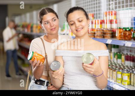 Zwei Frauen wählen Konservenfutter im Laden aus Stockfoto