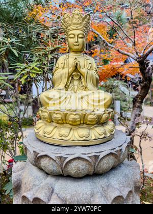 Goldene Buddha-Statue in einem lebendigen japanischen Garten Stockfoto