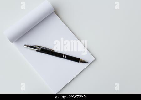 Schwarzer Stift und weißes Papier Notizblock Banner Hintergrund mit Kopierraum. Bürobedarf, Schulpapier, Bildung, Notizen machen, Konzept schreiben. Stockfoto
