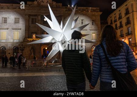 Barcelona, Barcelona, Spanien. Dezember 2024. Zwei Wochen vor Heiligabend spazieren die Menschen durch den Platz Sant Jaume in Barcelona, wo ein großer Stern die traditionelle Weihnachtskrippe ersetzt. (Kreditbild: © Marc Asensio Clupes/ZUMA Press Wire) NUR REDAKTIONELLE VERWENDUNG! Nicht für kommerzielle ZWECKE! Stockfoto