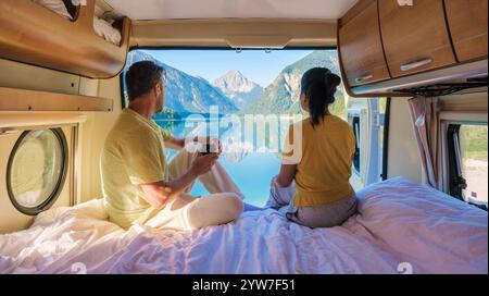 Ein vielseitiges Paar sitzt in einem Wohnmobil und genießt Kaffee und den atemberaubenden Blick auf einen norwegischen Fjord vom Fenster aus. Ein vielseitiger Mann und Frauen in einem Mobilheim Lodal Valley Norwegen Stockfoto