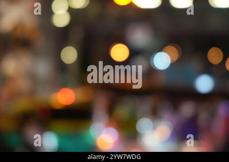 Verschwommener Blick auf die Straße mit Lichtern in der winterlichen regnerischen Nacht. Bokeh beleuchtet Hintergrund. Abstrakte künstlerische Fotografie. Stockfoto