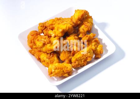 Knusprige, goldgebratene Hähnchennuggets auf einer weißen Keramikplatte Stockfoto